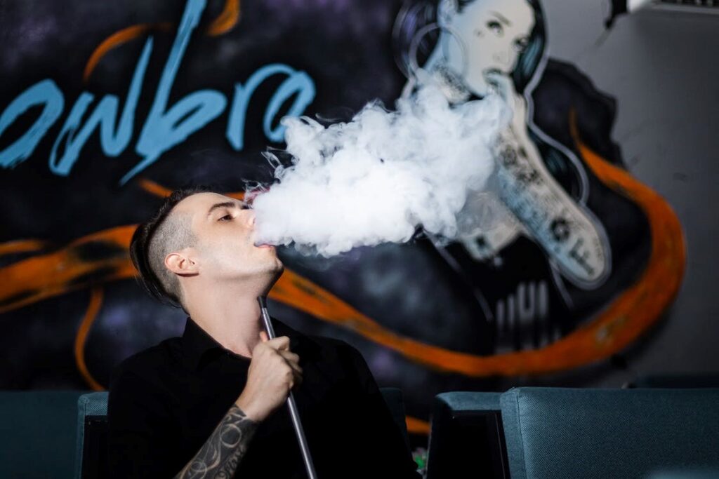  a young man showing off his vape cloud