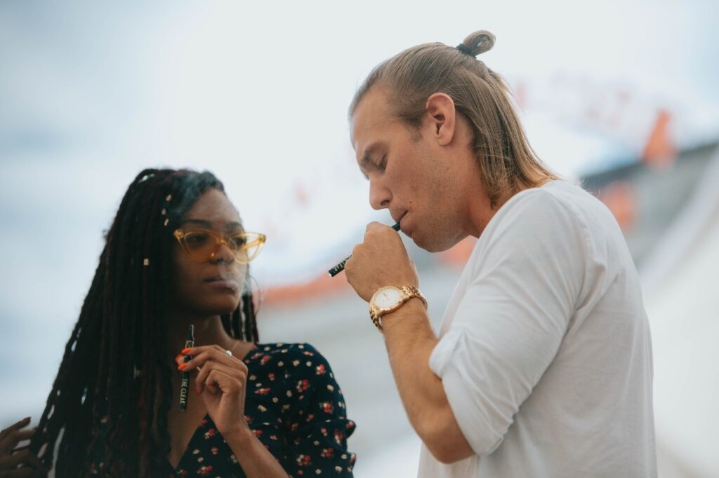 A man and woman using vape pens